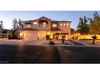 Inviting two-story home featuring a three-car garage, landscaped front yard, and warm exterior lighting at , Las Vegas, NV 89131