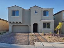 Two-story home featuring a neutral-colored stucco exterior and decorative brick driveway at 1027 Cambridge Park St, Las Vegas, NV 89148