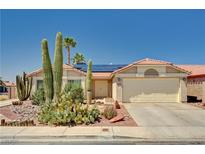 Charming single-story home with desert landscaping, tile roof and solar panels on a sunny day at 1536 Leatherleaf Dr, Las Vegas, NV 89123