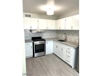 Updated kitchen featuring white cabinets, stainless steel appliances, and granite countertops at 212 Orland St # 22, Las Vegas, NV 89107