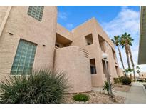 Beige building featuring unique architecture, landscaped grounds, palm trees, and clear blue sky at 2232 Aspen Mirror Way # 202, Laughlin, NV 89029