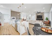 Bright, open-concept living space featuring a modern kitchen with a marble island and a comfortable seating area at 2353 Lauren Dr, Las Vegas, NV 89134