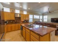 Open kitchen features a large island with a double sink and views of the living area at 2740 Carolina Blue Ave, Henderson, NV 89052