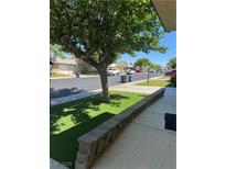 Front yard featuring desert landscaping, shade tree, and a view of the neighborhood street at 3831 Atlantis St, Las Vegas, NV 89121