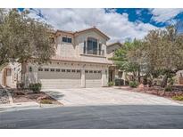 Charming stucco home with a tile roof, three-car garage and a well-maintained landscaped front yard at 4804 Laurentia Ave, Las Vegas, NV 89141