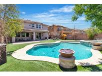 Resort-style backyard featuring a sparkling pool, lush lawn, and a charming playhouse perfect for outdoor enjoyment at 7545 Fontera Ct, Las Vegas, NV 89139