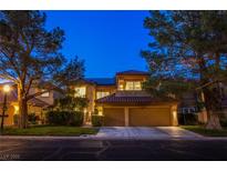 Inviting two-story home featuring a well-manicured lawn, mature trees and a convenient two-car garage at 7940 Castle Pines Ave, Las Vegas, NV 89113