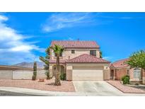 Charming two-story home featuring desert landscaping, a palm tree, and a two-car garage at 7964 Lovely Pine Pl, Las Vegas, NV 89143
