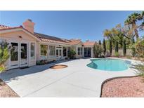 A beautiful backyard pool is surrounded by a desert landscape with palm trees at 8300 Slate Harbor Cir, Las Vegas, NV 89128