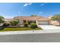 Inviting single-story home featuring a well-manicured front yard, a two-car garage, and a classic red tile roof at 10009 Netherton Dr, Las Vegas, NV 89134