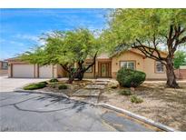 Charming single-story home with a three-car garage and mature trees in a well-kept front yard at 12780 Davis Wright Ct, Henderson, NV 89044
