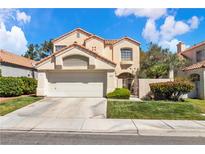 Charming two-story home with a well-manicured lawn, two-car garage, and gated front entry at 1825 Derbyshire Dr, Las Vegas, NV 89117