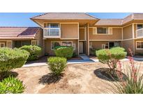 Two-story townhome showcasing manicured bushes, and a tiled roof at 2454 Paradise Village Way, Las Vegas, NV 89120
