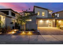 Contemporary home featuring a two-car garage, illuminated landscaping, and a modern design at 436 Crown Mesa Ave, Las Vegas, NV 89138