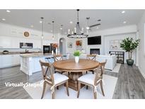 Bright open-concept living room with a modern kitchen, dining area, and fireplace at 472 Via Stretto Ave, Henderson, NV 89011