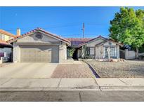 Charming single-story home with a well-maintained yard, desert landscaping, and a two-car garage at 6771 Shelter Ln, Las Vegas, NV 89103