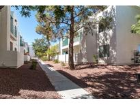 View of modern townhouse exteriors with neat landscaping and walkways under a clear blue sky at 7100 Pirates Cove Rd # 2065, Las Vegas, NV 89145