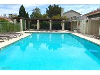 A beautiful community pool with lounge chairs and shaded pergola, perfect for relaxation and recreation at 9236 Canalino Dr, Las Vegas, NV 89134