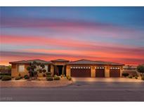 Beautiful home featuring a three-car garage, well-maintained landscaping, and a stunning colorful sunset sky at , Las Vegas, NV 89113