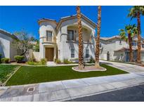Charming two-story home featuring stucco siding, balcony, manicured lawn, and desert landscaping at 153 Cascade Lake St, Las Vegas, NV 89148