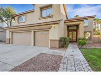 Stunning two-story home featuring a three-car garage, lush green lawn, and charming desert landscaping at 249 Gentle Springs Dr, Henderson, NV 89012