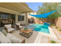 A luxurious backyard pool with an outdoor seating area for relaxation and entertaining guests at 3440 Bella Viera Ct, Las Vegas, NV 89141
