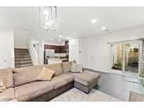 Bright living room features neutral colors, modern lighting, tile flooring, and direct access to the outdoor living space at 4533 Lime Straight Dr, Las Vegas, NV 89115