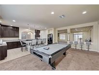 Open game room featuring a pool table, kitchen island with seating, and a view into a living area at 5448 Tulip Hill Ave, Las Vegas, NV 89141
