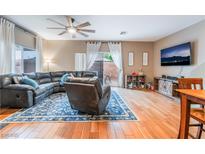 Cozy living room featuring hardwood floors, a comfortable sectional sofa, and a modern ceiling fan at 6312 Snap Ridge St # 101, North Las Vegas, NV 89081