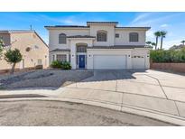 Inviting stucco two-story home with a three-car garage and a blue front door at 7492 Midfield Ct, Las Vegas, NV 89120