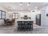 Bright kitchen with stainless steel appliances, center island, and adjacent dining area at 778 Dainty Daffodil St, Henderson, NV 89011