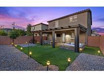 A backyard with pavers, grass, spa, pergola, and bistro lights is great for entertaining guests at 8013 Green River Knob St, Las Vegas, NV 89113