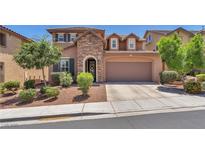 Charming two-story home featuring a stone facade, manicured landscaping, and attached two-car garage at 10353 Settlers Run Ave, Las Vegas, NV 89166