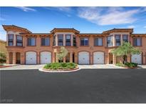 Attractive townhome complex featuring garages, neat landscaping, and an appealing architectural style with neutral paint at 30 Via Vasari # 102, Henderson, NV 89011