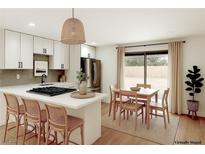 Bright eat-in kitchen features a center island with bar stool seating and stainless steel appliances at 333 Rossmoyne Ave, North Las Vegas, NV 89030