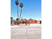 Cozy single-story home featuring a large driveway, solar panels, and low-maintenance landscaping with mature palm trees at 4062 Monthill Ave, Las Vegas, NV 89121