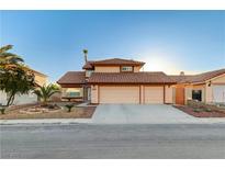 Charming two-story home featuring a three-car garage, tile roof, and desert landscaping in the front yard at 4835 Illustrious St, Las Vegas, NV 89147