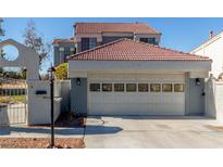 View of the garage and entry gate of this well maintained home featuring a terracotta roof and neutral stucco exterior at 5221 Crooked River Cir, Las Vegas, NV 89149