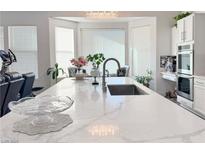 Bright kitchen features a large island with a quartz countertop and a stainless steel sink at 5422 Nestled Moon Ct, Las Vegas, NV 89131