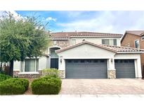 Two-story home featuring a tile roof, three-car garage, and manicured landscaping in a suburban neighborhood at 7020 Puetollano Dr, North Las Vegas, NV 89084