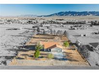 Expansive aerial view of desert home with an orange roof and mountain views at 1601 Iguana St, Pahrump, NV 89048