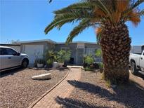 Charming single-story home featuring desert landscaping, a brick walkway, and a mature palm tree in the front yard at 2725 Webster St, North Las Vegas, NV 89030