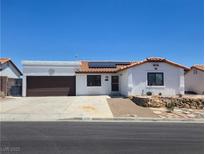 Charming single-story home with white stucco exterior, brown garage door, and desert landscaping at 2822 La Palma Dr, Laughlin, NV 89029