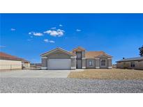 Charming single-story home boasts a neutral color scheme, concrete driveway and a two-car garage at 3326 Mount Charleston Dr, Pahrump, NV 89048