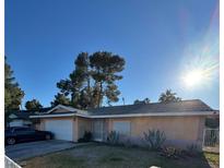 Charming single-story home featuring desert landscaping, a two-car garage, and a welcoming entrance gate at 5049 Spring Oak St, Las Vegas, NV 89120