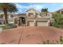 Attractive two-story home featuring a terracotta-colored driveway, a two-car garage and lush landscaping at 56 Grossinger Ct, Henderson, NV 89074