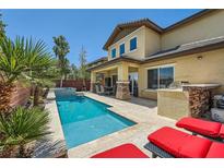 Beautiful backyard with a private pool, lounge chairs and an outdoor kitchen area at 5662 Oak Bend Dr, Las Vegas, NV 89135