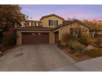 Inviting two-story home featuring a spacious driveway and a well-manicured desert landscape at 7438 Desertscape Ave, Las Vegas, NV 89178