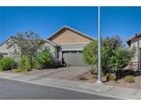 Cozy single-story home featuring a two-car garage, desert landscaping, and a brick driveway at 76 Summer Rhapsody Ave, Henderson, NV 89015
