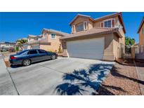 Inviting two-story home with a tile roof, attached garage, and a neatly maintained front yard with a long driveway at 8370 Lost Lake Ct, Las Vegas, NV 89147
